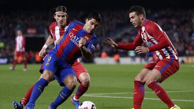 Barcelona’s Luis Suarez challenges Atletico’s Filipe Luis, left, and Lucas Hernandez, right. Manu Fernandez / AP