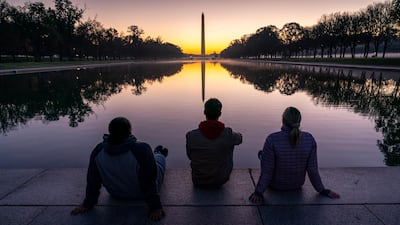 A trio of friends watch the sunrise at the Reflecting Pool near the Lincoln Memorial in Washington, two days after Election Day. AP Photo