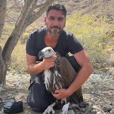 Dr Panos Azmanis with a lappet-faced vulture chick tagged in Oman. The young bird has since been sighted at Dubai Desert Conservation Reserve. Photo: Dr Panos Azmanis