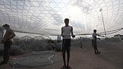 Fishermen at the Mina Port in Abu Dhabi tend to their nets. Some members of the Federal National Council have complained about the preponderance of Asians in the industry.