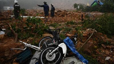 People inspect the damage caused by the landslide. AFP