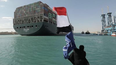 A man waves the Egyptian flag after the Panama-flagged MV 'Ever Given' container ship was fully dislodged from the banks of the Suez. AFP