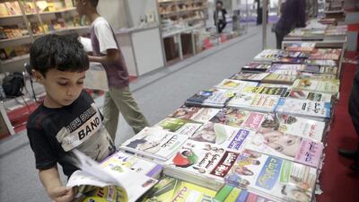 Suhail Omar, 12, looks through books at the Abu Dhabi Book Fair 2013 (Sammy Dallal / The National)