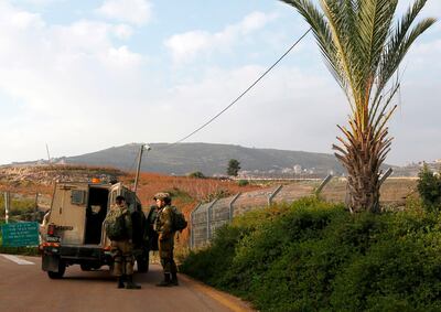 Israeli soldiers standing outside a military vehicle near the border with Lebanon. AFP
