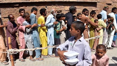 People affected by floods queuing to receive free food distributed by the Pakistan Red Crescent Society in Larkana. EPA
