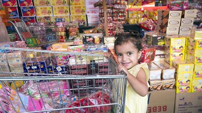 Families in Ras Al Khaimah stock up on sweet treats to be handed out to children during Haq Al Laila. Leslie Pableo for The National