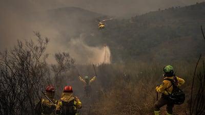 A helicopter drops water over the flames in Larouco, in Galicia, Spain. Reuters