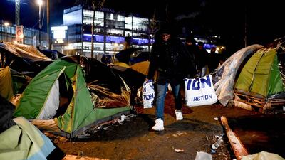 Migrants are evacuated by police forces early on Tuesday morning. AFP