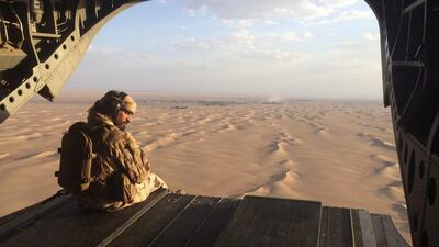 An Emirati gunner watches for enemy fire from the rear gate of a UAE Chinook military helicopter flying over Yemen. Adam Schreck, File/AP Photo
