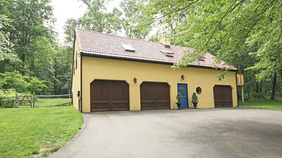 A detached pool house has a heated pool, three garage bays and a second-floor caretaker cottage