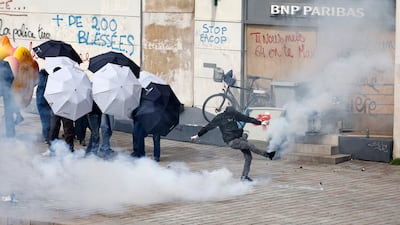 Youths kick tear gas grenades during a demonstration in Nantes, western France. AP