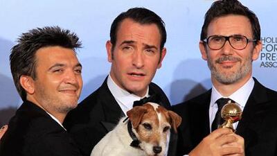 Producer Thomas Langmann (L), actor Jean Dujardin (C), winner of the best performance by an actor in a motion picture - comedy or musical, and director Michel Hazanavicius pose backstage with Uggie the dog, after "The Artist" won the best comedy or musical motion picture award at the 69th annual Golden Globe Awards in Beverly Hills, California January 15, 2012. REUTERS/Lucy Nicholson (UNITED STATES - Tags: ENTERTAINMENT PORTRAIT) (GOLDENGLOBES-BACKSTAGE)