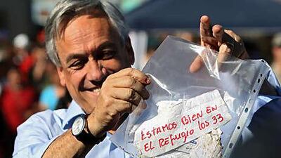 Chilean president Sebastian Pinera holds up a message from the trapped miners reading: all 33 of us are fine in the shelter.