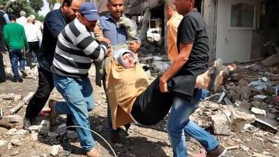 A woman is evacuated from the site where car bombs exploded on Saturday near the town hall in Reyhanli, just a few kilometres from the main border crossing into Syria. AFP