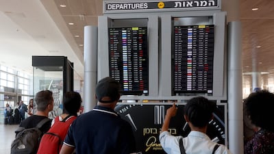 Passengers look at the departures board at Ben Gurion Airport in Tel Aviv showing cancelled flights. AFP