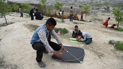 Boys prepare to fly kites during a kite battle.