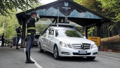 A police officer salutes as a hearse passes by. AP Photo