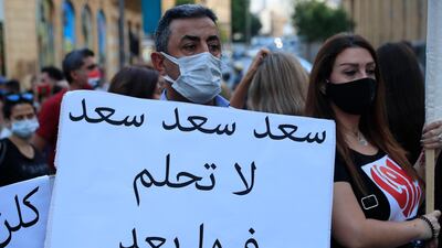 An anti-government protester holds an Arabic placard that reads: "Saad don't dream on it any more," during a protest to denounce the naming of former Prime minister Saad Hariri as a potential candidate as the country's new prime minister, in downtown Beirut. AP Photo