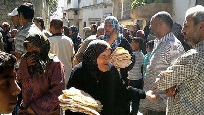A handout image released by the Syrian opposition's Shaam News Network shows Syrians lining up to collect bread in Houla, the scene of a massacre last month.