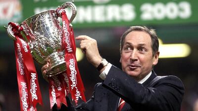In this file photo taken on March 2, 2003 Liverpool's French manager Gerard Houllier holds the cup aloft celebrating victory over Manchester United in the Worthington cup final at the Millenium stadium in Cardiff. Ex-Liverpool manager Gerard Houllier has died at the age of 73, it was announced on December 14, 2020. AFP