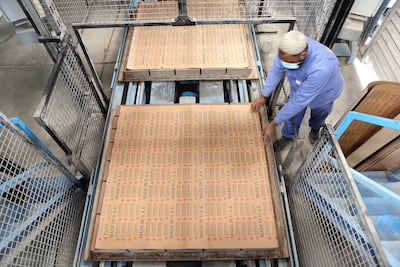 A worker packaging goods at a factory in Dubai. Pawan Singh / The National
