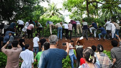 Demonstrators scale the walls of the Prime Minister's residence, leading to her fleeing the country. AFP