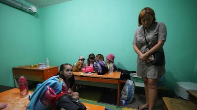 Children take shelter in the basement of the kindergarten after the missile attack in Kyiv. AFP