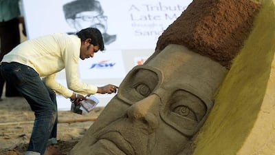 An Indian artist creates a sand sculpture of the late Bollywood playback singer Manna Dey. Punit Paranioe / AFP