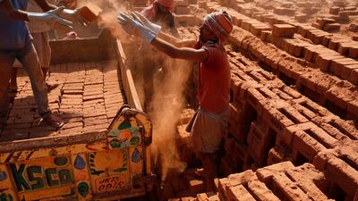 Laborers load bricks on to a truck inside a brick kiln in central Kashmir's Budgam district, some 25 kilometers from Srinagar. Farooq Khan/EPA