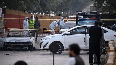 Forensic experts examine a car after a suicide bombing outside the district court in Islamabad. AFP
