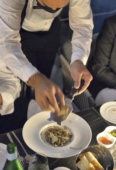 A server shaves white truffle on a tagliolini pasta dish at Roberto's