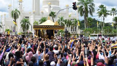 Sultan Hassanal Bolkiah waves to people as he passes by. Ahim Rani / Reuters