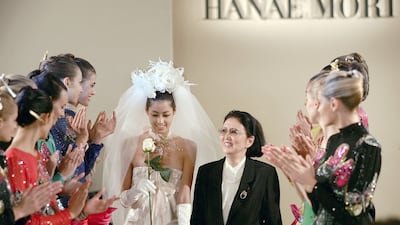 (FILES) This file photo taken on July 7, 2004 shows Japanese designer Hanae Mori (centre R) walking on the catwalk after the presentation of her autumn-winter 2004-05 haute couture collection in Paris. - Japanese fashion designer Hanae Mori, who cracked the elite world of Parisian haute couture, has died at her home in Tokyo aged 96, Japanese media reported on August 18, 2022. (Photo by JEAN-PIERRE MULLER / AFP)
