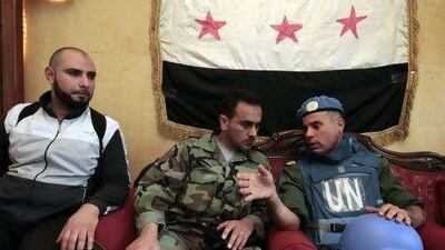 The head of the United Nations observation team, Col Ahmed Himmiche, right, speaks with the Free Syrian Army commander Abu Kutaiba in the old city of Homs yesterday. Regime forces reportedly killed students at university in Aleppo yesterday, casting new doubt on the UN peace plan.