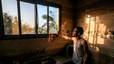 A man inspects a broken window after an Israeli air strike, east of Al Bureij camp for Palestinian refugees in the central Gaza Strip on August 15, 2020. AFP