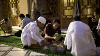 Abdul Hameed al Warhi, 23, centre, a Sufi follower, breaks fast at Tijani zawiya.