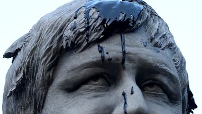 Oil thrown by Greenpeace demonstrators in an act of symbolism drips down the face of the Boris Johnson statue. Reuters