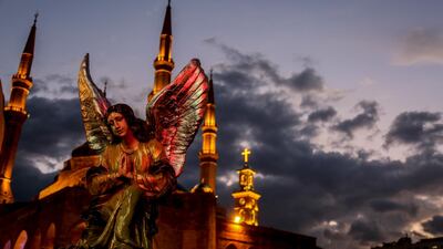 A statue of an angel in front of the Al Ameen mosque is lit up against the sunset in central Beirut. EPA