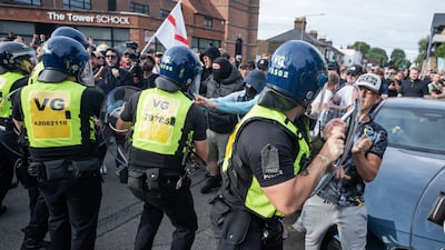 An anti-immigration protester tries to get through the cordon of riot police outside The Bell Hotel in Epping, Essex. Getty Images