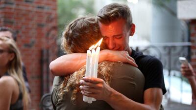 Brett Morian, from Daytona Beach, hugs an attendee during the candlelight vigil at Ember in Orlando, Florida, on Sunday, June 12. Joshua Lim / Orlando Sentinel via AP