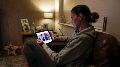 Teacher Wendy Couldridge watches on a device as Britain's Prime Minister Boris Johnson announces a lockdown in England. Reuters