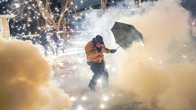 A protester uses an umbrella as a shield from projectiles fired by federal law enforcement agents in Minneapolis, Minnesota. Demonstrators took to the streets after a shooting incident involving federal personnel. Reuters
