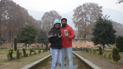 Indian tourists pose with their smartphones at Nishat Garden in Srinagar. AFP