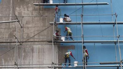 Workers paint the building of a new branch of a SM mall in Paranaque, metro Manila. Erik De Castro / AP Photo