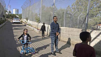 Palestinian Saadat Sabri Gharib, centre, walks with family members between Israeli army barriers that lead to his house.