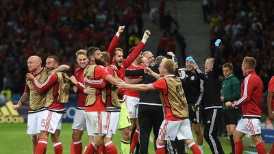 Wales players celebrate after Sam Vokes scored their third goal. Paul Ellis / AFP