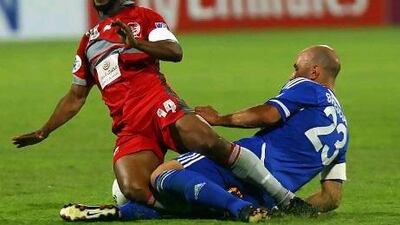 Al Nasr's Mark Bresciano, right, slides in on Lekhwiya midfielder Bakari Kone last night. Walter Zenga's side earned their first win in this season's competition with a 2-1 victory. Satish Kumar / The National