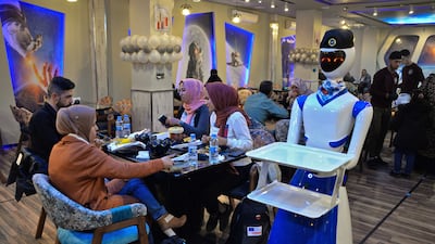 A robot waiter carries empty trays after delivering an order to diners at the restaurant.