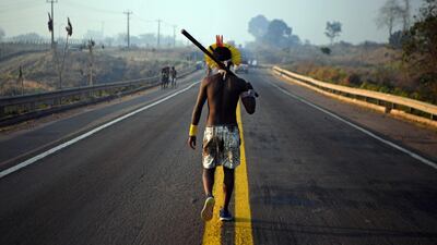 A member of the Kayapo tribe walks along the middle of the BR163 highway during a protest outside Novo Progresso in Para state, Brazil. AFP