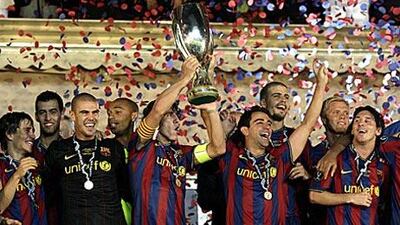 Barcelona's captain Carlos Puyol, centre, lifts the European Super Cup after defeating Shakhtar at Louis II stadium in Monaco.